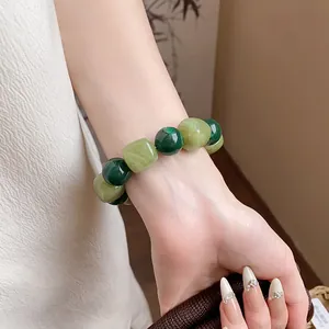 Close-up of irregular green acrylic beaded bracelet on woman's wrist