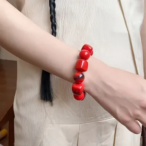 Detailed view of a vibrant red acrylic irregular geometric beaded bracelet on a wrist