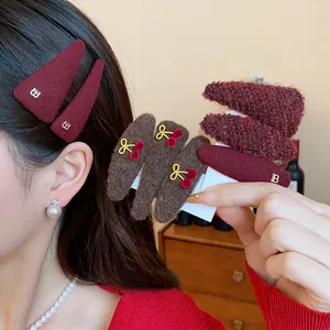 Macro view of plush red and brown autumn hair clips with cute cherry accents.