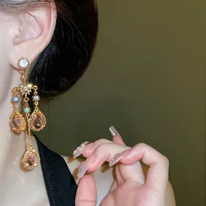 Elegant vintage gold-toned star and sparkling crystal teardrop tassel earrings shown on model