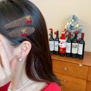 Close-up of plush brown hair clips with red cherry and bow details on hair.