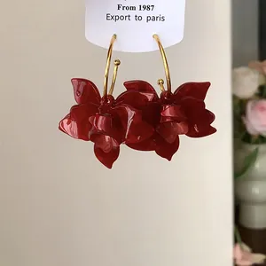 Detailansicht der Vintage-Ohrringe mit roten Harzblumen und goldfarbenen Creolen