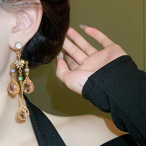 Detail of vintage palace style star earrings with peach teardrop crystal tassels