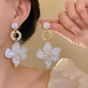 Elegant white resin flower drop earrings with a golden textured ring detail for women