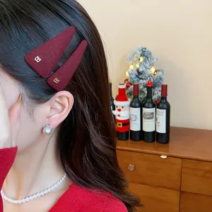 Detail of burgundy velvet triangular hair clips worn by a model in a festive setting