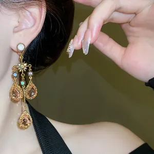 Detailed close-up of a vintage crystal star drop earring with champagne charms.