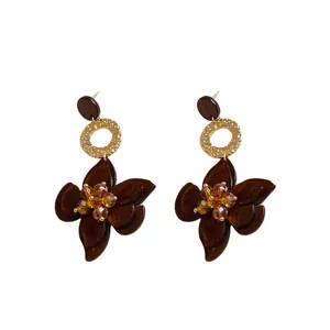 Elegant brown resin flower drop earrings with gold rings and crystal center accents.