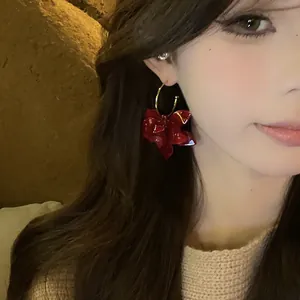 Detailaufnahme eines vintage dunkelroten Harz-Blumenohrrings mit goldenem Reifen