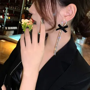 Detailed side view of elegant silver needle rhinestone bow long tassel earrings for women