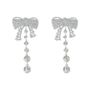Elegant silver bow earrings with sparkling rhinestone tassels for a glamorous statement.