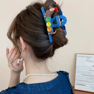 Detailansicht einer blauen Denim-Haarklammer mit süßer Dackel-Dekoration im Haar