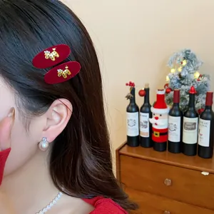 Close-up of elegant red velvet BB hair clips with gold dog charms on model's hair