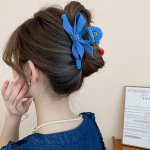 Haarklammer aus blauem Denim-Stoff mit Schleife an eleganter Hochsteckfrisur