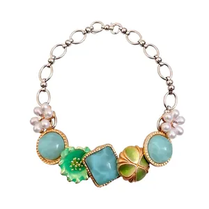 Bohemian style necklace with pearl flower charms and turquoise stones on white background