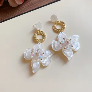 Close-up detail of forest style resin flower dangle earrings with iridescent crystals