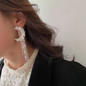 Detailed close-up showing the sparkling rhinestones of moon-shaped tassel earrings