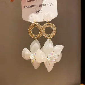 Detail view of resin flower drop earrings with hammered gold rings and silver needles