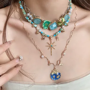 Close-up of layered Bohemian necklaces with shells, stars, and colorful floral pendants.
