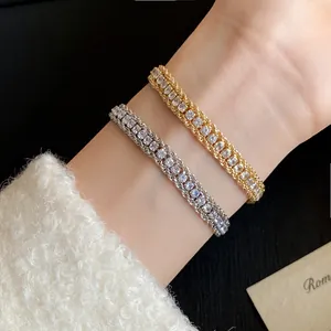 Close-up of gold and silver sparkling rhinestone wrapped chain bracelets on wrist.