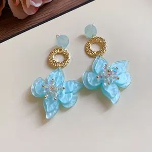 Elegant sky blue resin flower drop earrings with gold textured rings and crystals