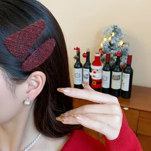 Close-up of red plush knitted triangular hair clips worn by a model in holiday setting