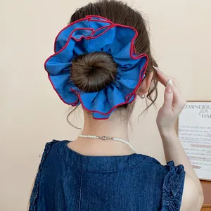 Nahaufnahme des blau-roten doppellagigen Haargummis mit Falten am Dutt-Styling