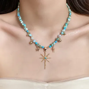 Detailed view of bohemian shell bead necklace with gold starburst and star charms