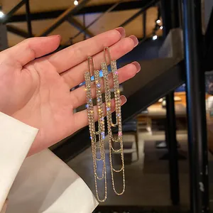 Detailed close-up of elegant gold-toned long tassel earrings adorned with sparkling crystals