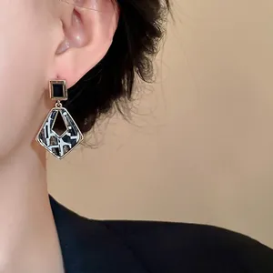 Elegant geometric hollow dangle earrings featuring square top and patterned rhomboid drop