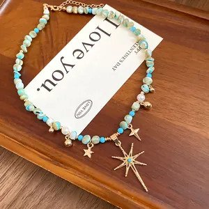 Macro detail of Bohemian beaded necklace featuring turquoise accents and gold star charms.