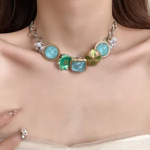 Detail view of a bohemian style necklace with blue stones and pearls on model's neck