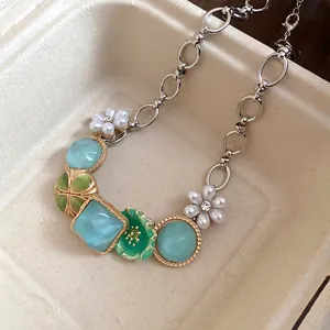 Detailed view of a bohemian necklace with white pearl flowers and blue turquoise-like beads.