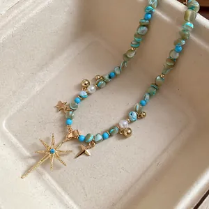 Macro view of Bohemian beaded necklace with blue stones, pearls, and golden star pendant