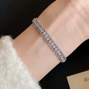 Macro detail of a vintage silver twisted chain bracelet with sparkling crystals on a wrist.