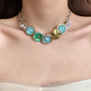 Detailed view of a Bohemian holiday necklace featuring green flower and pearl pendants