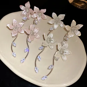 Vista dettagliata degli orecchini a fiore con zircone e aghi d'argento in rosa e bianco.