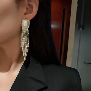 Elegant silver-tone long multi-strand rhinestone tassel earrings worn by an Asian model