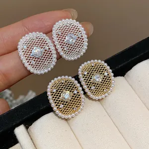 Dettaglio macro degli eleganti orecchini a rete placcati oro 18k con zirconi e perle