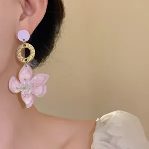 Detailed view of elegant pink resin flower drop earrings with gold ring and crystal