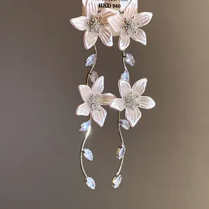 Dettaglio di eleganti orecchini a fiore rosa con nappine in zircone scintillante