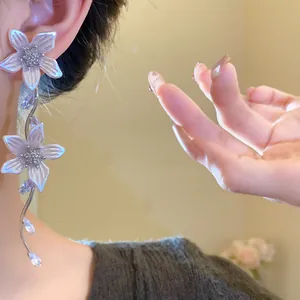 Primo piano di eleganti orecchini a nappa con fiori di zircone e perle su una modella