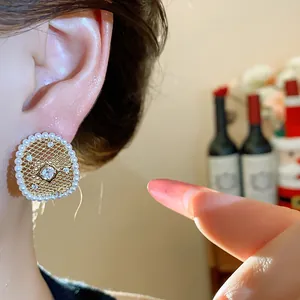 Primo piano di eleganti orecchini a maglia placcati oro 18k con perle e zirconi brillanti