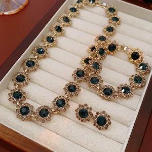 Detailed view of vintage floral rhinestone necklace, bracelet and earring jewelry set box.
