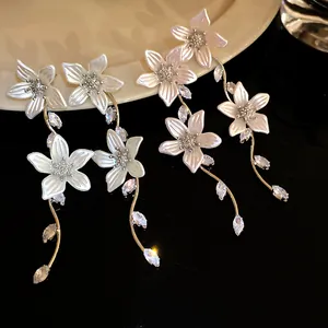 Primo piano di eleganti orecchini a fiore con finitura perlata e zirconi scintillanti