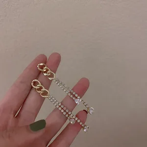 Close-up of elegant gold chain tassel earrings with sparkling rhinestones
