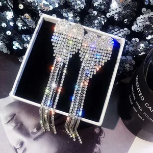 Detailed view of oversized full-rhinestone bow tassel earrings in a box