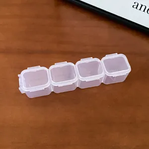 Detailed macro view of a 4-compartment transparent plastic jewelry storage box on wood