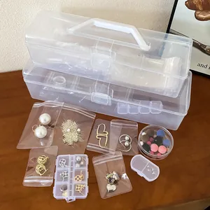 Close-up of portable clear plastic jewelry storage box with assorted accessories