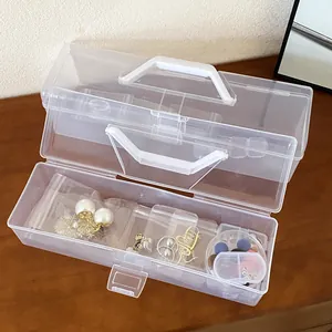 Close-up of portable transparent plastic jewelry box with handle showing internal storage.