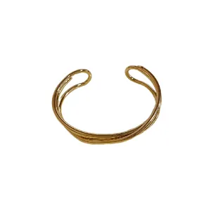 Bracciale rigido aperto multistrato finitura dorata minimalista con design incrociato